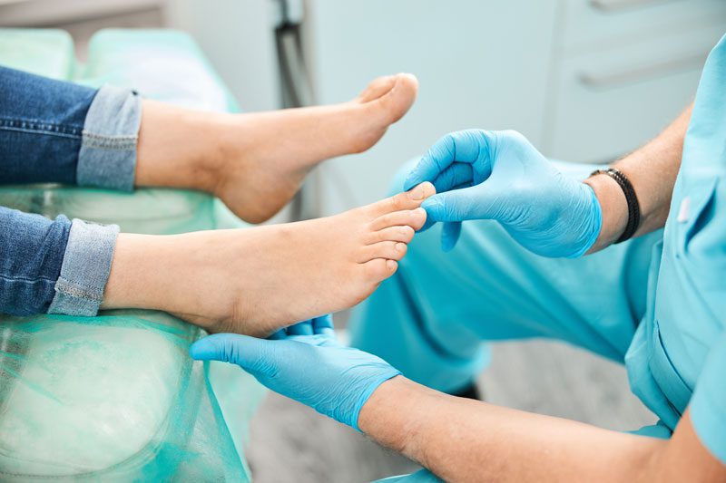 Close up portrait of female feet on the medical chair while doctor podiatrist gives treatment